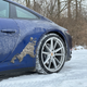 a blue 2023 porsche 911 carrera on a snow-covered road in michigan